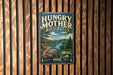 A vintage metal sign for Hungry Mother State Park, featuring a scenic mountain landscape with a river and pine trees.
