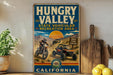 A vintage-style sign for the Hungry Valley State Vehicular Recreation Area in California, featuring an illustration of a person riding a dirt bike and a sign that says "OH VE H FUN AHEAD!"