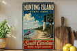 A vintage-style metal sign for Hunting Island State Park, featuring a lighthouse, beach, and birds, is displayed on a shelf next to a wooden cutting board and some lemons.