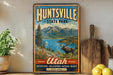A vintage-style metal sign for Huntsville State Park in Utah, featuring a moose and a scenic mountain landscape.