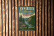 A vintage-style metal sign for Hyner Run State Park in Pennsylvania, featuring a scenic mountain landscape with a river.