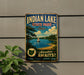 A vintage-style metal sign for Indian Lake State Park in Ohio, featuring a scenic illustration of a lake, trees, and a sailboat.