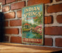 A vintage-style metal sign for Indian Springs State Park in Georgia, featuring a scenic illustration of a pond and a gazebo.