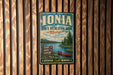 A vintage-style metal sign for the Ionia State Recreation Area in Michigan, featuring a scenic illustration of a lake, forest, and canoe.