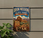 A vintage-style sign for the Iron Mission State Park Museum in Utah, featuring an illustration of the historic mission building and surrounding landscape.