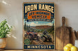 a vintage-style sign for the Iron Range Off-Highway Vehicle State Recreation Area in Minnesota, with illustrations of ATVs and a scenic landscape.