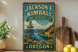 A vintage-style sign for the Jackson F. Kimball State Recreation Site in Oregon, featuring a scenic landscape with a mountain, lake, and pine trees.