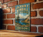 A vintage metal sign for the Jackson F. Kimball State Recreation Site in Oregon, featuring a scenic mountain landscape and a lake.