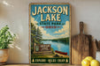 A vintage-style sign for Jackson Lake State Park in Ohio, featuring a scenic illustration of the lake surrounded by trees and a canoe.
