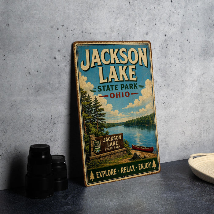 A vintage-style metal sign for Jackson Lake State Park in Ohio, featuring a scenic illustration of the lake and surrounding landscape.