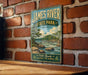 A vintage-style metal sign for James River State Park in Virginia, featuring a scenic illustration of a river and mountains.