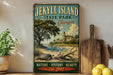 A vintage-style sign for Jekyll Island State Park in Georgia, featuring a scenic illustration of a beach, palm trees, and a large building.