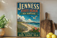 A vintage-style sign for "Jenessy State Beach, New Hampshire" featuring a beach scene with a lighthouse, a seagull, and a wooden fence.