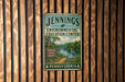 A metal sign for the Jennings Environmental Education Center in Pennsylvania, featuring a scenic landscape with a lake and a bird.