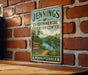 A vintage-style sign for theENNINGS Environmental Education Center in Pennsylvania, featuring a scenic landscape with a lake, trees, and a bird.