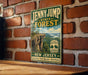 A vintage-style metal sign for the Jenny Jump State Forest in New Jersey, featuring a scenic image of a cliff overlooking a forest.