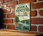 A vintage-style metal sign for John A. Minetto State Park in Connecticut, featuring a scenic landscape with a lake, trees, and a sailboat.