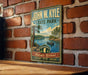 A vintage-style metal sign for John W. Kyle State Park, featuring a scenic landscape with a lake, trees, and a boat.