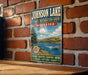 A vintage-style sign for Johnson Lake, the state recreation area in Nebraska, featuring a scenic image of a lake and mountains.