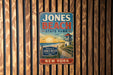 A vintage-style metal sign for Jones Beach State Park in New York, featuring a lighthouse and a beach scene.