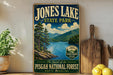 A vintage-style sign for Jones Lake State Park, featuring a scenic landscape with pine trees, mountains, and a lake.