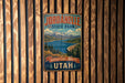 A vintage metal sign for Jordanelle State Park in Utah, featuring a scenic mountain landscape with a lake and pine trees.