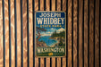 A vintage-style metal sign for Joseph Whidbey State Park in Washington, featuring a scenic landscape with a pine tree and a body of water.
