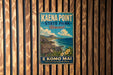 A vintage-style sign for Kaena Point State Park in Hawaii, featuring a scenic illustration of the park's landscape with mountains, ocean, and tropical flowers.