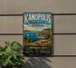 A vintage-style metal sign for Kanopolis State Park in Kansas, featuring a scenic landscape with a lake, mountains, and a sailboat.