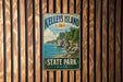 A vintage metal sign for Kelley's Island State Park, Ohio, featuring a scenic landscape with a lake, cliffs, and trees.