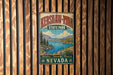 A vintage metal sign for Kershaw-Ryan State Park in Nevada, featuring a scenic landscape with mountains, a lake, and pine trees.