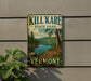 A vintage-style sign for Kill Kare State Park in Vermont, featuring a scenic landscape with a lake, mountains, and pine trees.