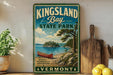 A vintage-style sign for Kingsland Bay State Park in Vermont, featuring a scenic illustration of a lake, pine trees, and a red canoe.