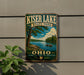 A vintage-style metal sign for Kiser Lake State Park in Ohio, featuring a scenic landscape with a lake, trees, and people enjoying the outdoors.