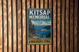 A vintage metal sign for Kitsap Memorial State Park in Washington, featuring a scenic image of the park and a boat on the water.
