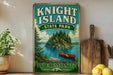 A vintage-style sign for Knight Island State Park in Vermont, featuring a scenic illustration of a lake, island, and canoe.