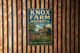 A vintage-style metal sign for Knox Farm State Park, featuring a house and trees, is displayed on a wooden wall.