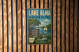 A vintage metal sign for Lake Alma State Park, featuring a scenic image of a lake, trees, and a sailboat, along with the text "BOATING, FISHING, HIKING" and "Adventure Awaits!"