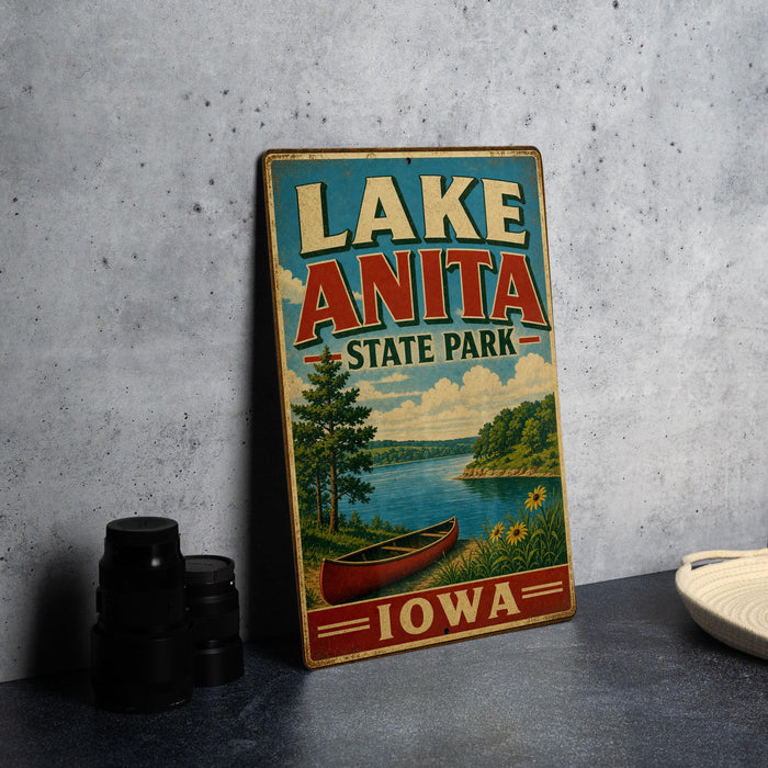A vintage-style sign for Lake Anita State Park in Iowa, featuring a scenic illustration of a lake, canoe, and surrounding landscape.