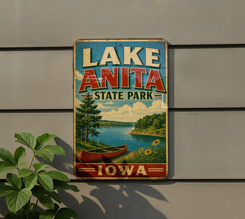 A vintage-style sign for Lake Anita State Park in Iowa, featuring a scenic landscape with a canoe on the lake and a cloudy sky.