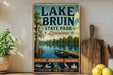 A vintage-style sign for Lake Bruin State Park in Louisiana, featuring a scenic image of a lake, trees, and a boat.
