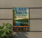 A vintage-style sign for Lake Bruin State Park in Louisiana, featuring a scenic illustration of a lake, trees, and a boat.
