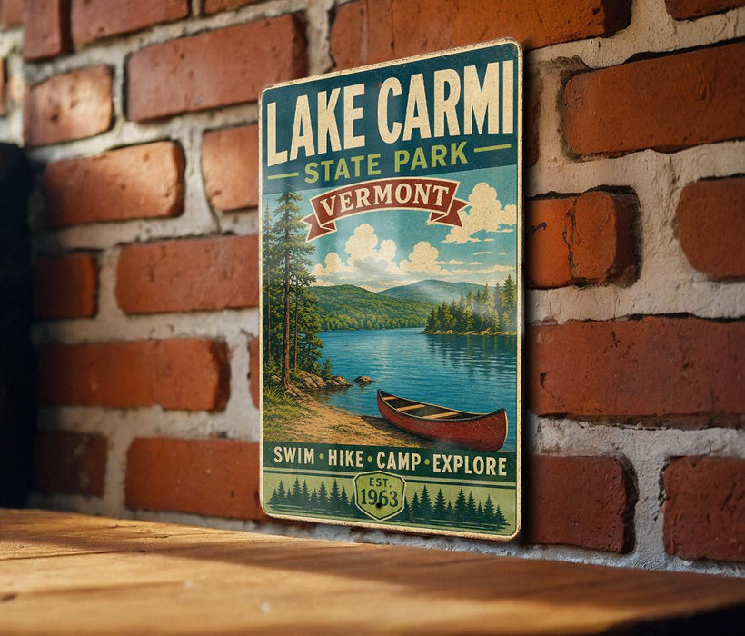 A vintage-style sign for Lake Carmi State Park in Vermont, featuring a scenic image of a lake, mountains, and a canoe.
