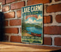 A vintage-style sign for Lake Carmi State Park in Vermont, featuring a scenic image of a lake, mountains, and a canoe.