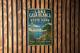 A vintage-style sign for Lake Casa Blanca, an international state park in Texas, featuring a scenic landscape with a lake, palm trees, and a desert landscape.