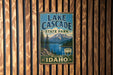 A vintage-style metal sign for Lake Cascade State Park in Idaho, featuring a scenic mountain landscape and a lake.