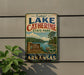 A vintage-style sign for Lake Catherine State Park in Arkansas, featuring a scenic landscape with a lake, mountains, and a sign indicating the park's name.