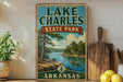 A vintage-style sign for Lake Charles State Park in Arkansas, featuring a scenic illustration of a lake surrounded by pine trees and mountains.