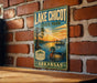 A vintage-style sign for Lake Chicot State Park in Arkansas, featuring a duck and a sunset over a lake.