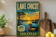 A vintage-style sign for Lake Chicot State Park in Arkansas, featuring a duck swimming in a lake and a sunset in the background.